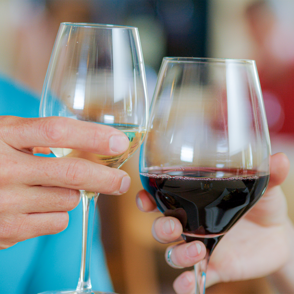 Wine glasses being held up together by a couple