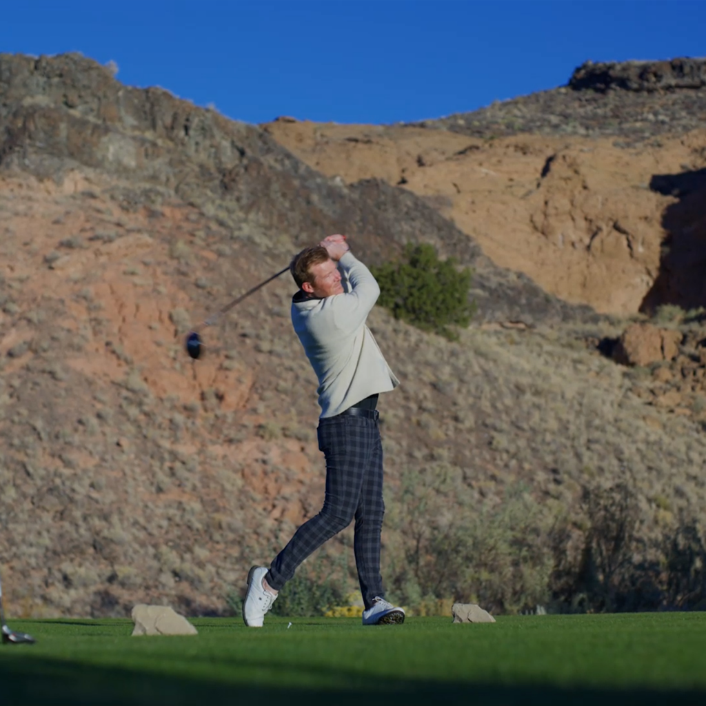 Man hitting a golf ball off a tee